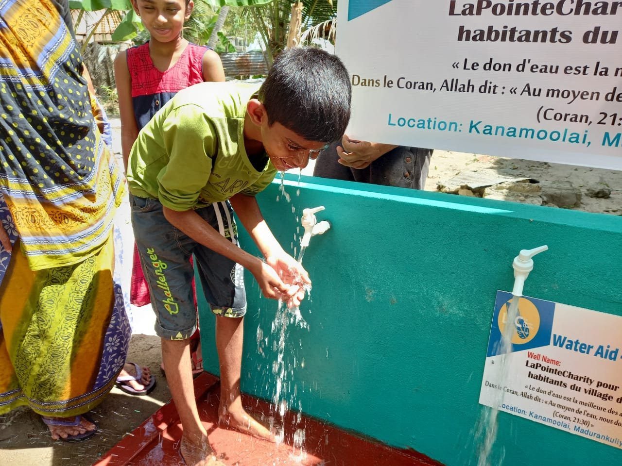 Child washing hands at a tap.