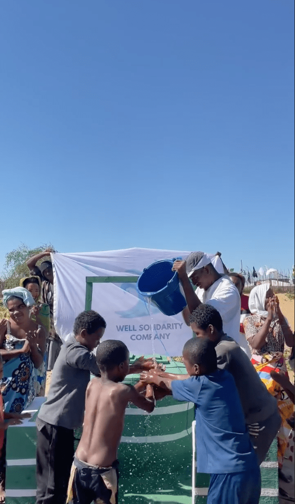 People washing their hands at a community well.