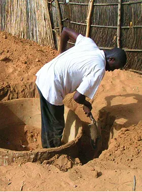 Person digging the ground with a shovel.
